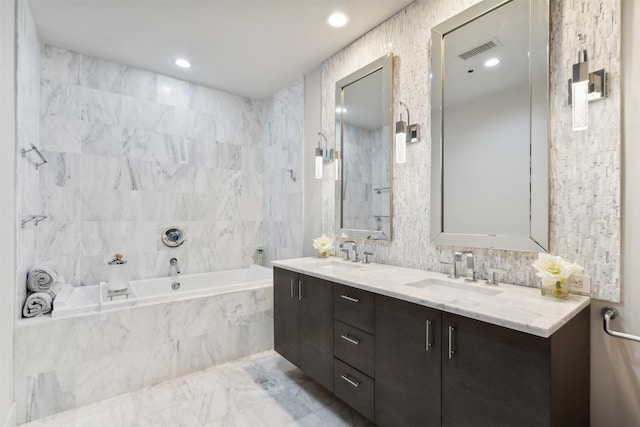 bathroom featuring tiled bath and vanity