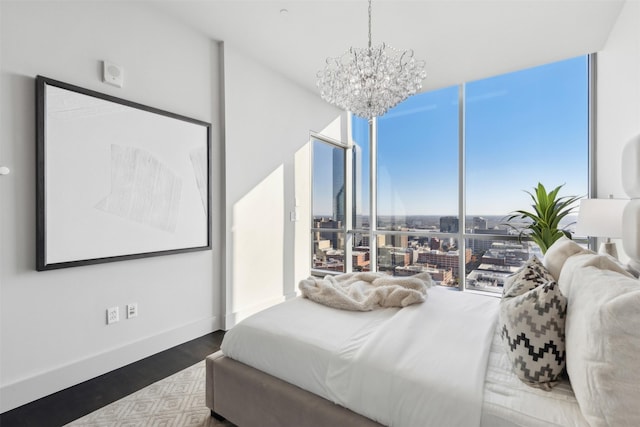 bedroom featuring hardwood / wood-style floors, expansive windows, and a notable chandelier