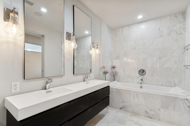 bathroom featuring vanity and a relaxing tiled tub