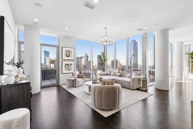 living room featuring dark wood-type flooring, a wealth of natural light, a wall of windows, and a notable chandelier