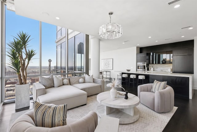 living room with a wall of windows, a chandelier, and hardwood / wood-style floors