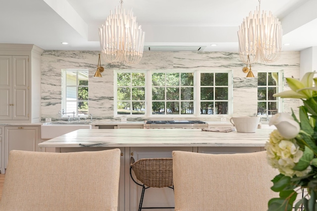 interior space with light stone counters, hanging light fixtures, and a chandelier