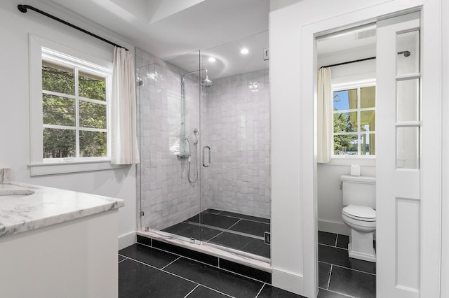 bathroom with walk in shower, vanity, toilet, and tile patterned floors