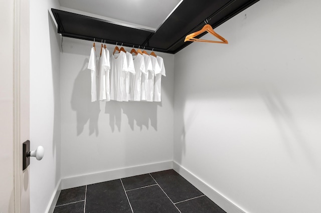 spacious closet with dark tile patterned floors