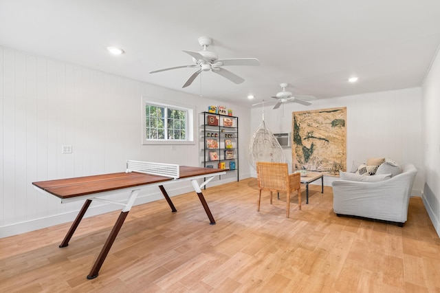 rec room with wooden walls and light hardwood / wood-style flooring