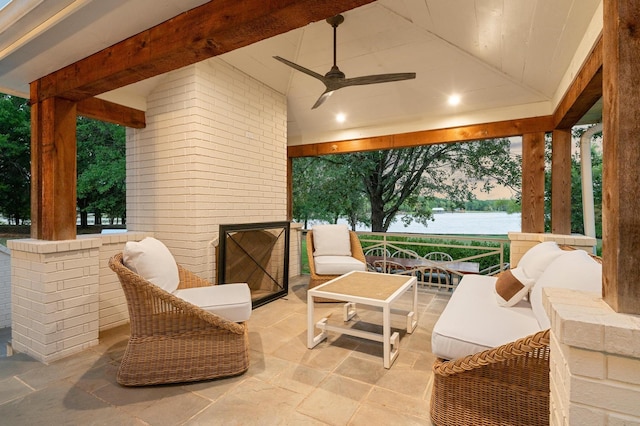 patio terrace at dusk with a water view and ceiling fan