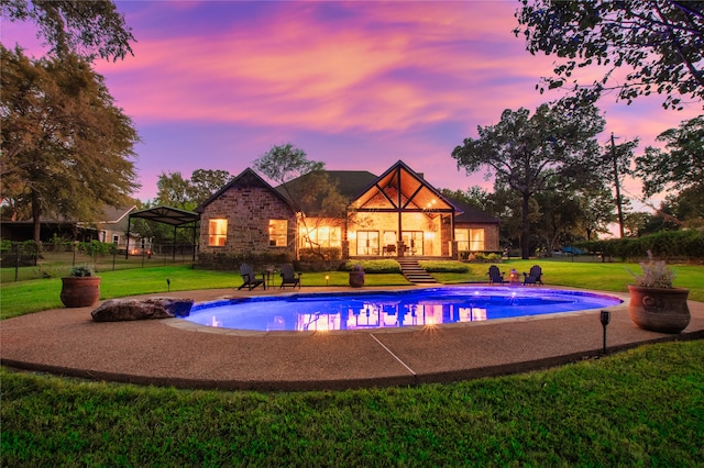 pool at dusk with a lawn