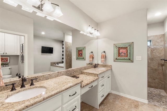 bathroom with toilet, vanity, and tiled shower