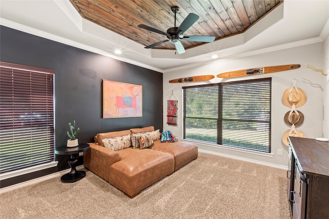 living room with ceiling fan, a tray ceiling, light carpet, and crown molding