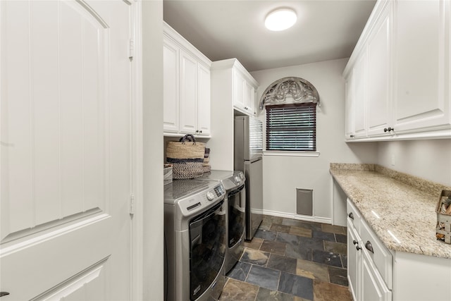 laundry room with washer and clothes dryer and cabinets