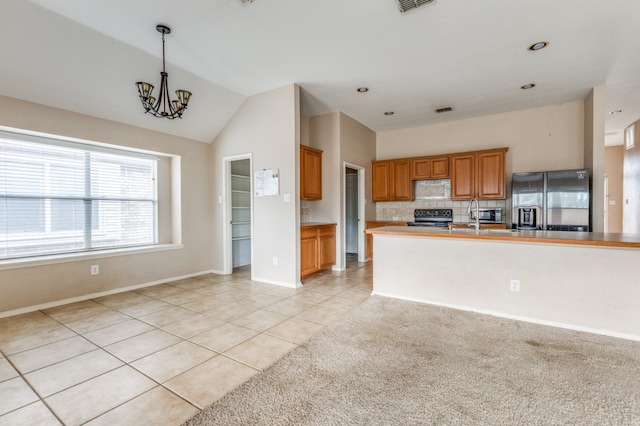 kitchen featuring a notable chandelier, vaulted ceiling, black appliances, decorative light fixtures, and light tile patterned floors