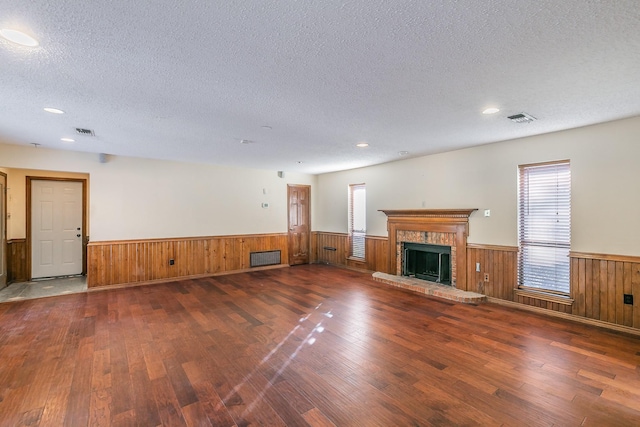 unfurnished living room featuring dark hardwood / wood-style floors, a fireplace, and a textured ceiling