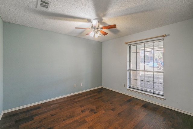 spare room with dark hardwood / wood-style flooring, ceiling fan, and a textured ceiling