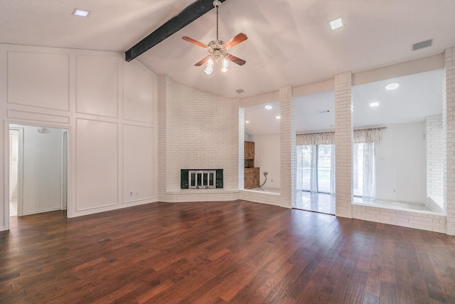 unfurnished living room featuring dark wood-type flooring, ornate columns, vaulted ceiling with beams, a brick fireplace, and ceiling fan