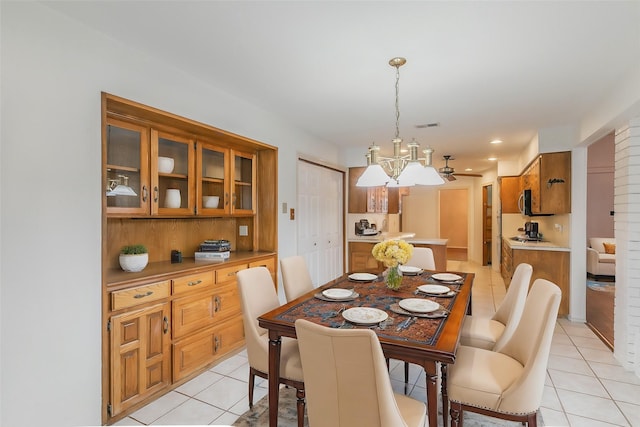 tiled dining room with a notable chandelier