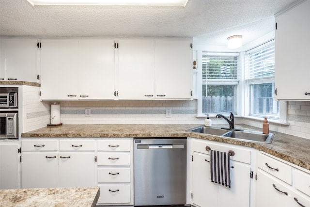 kitchen featuring stainless steel appliances, white cabinetry, and sink