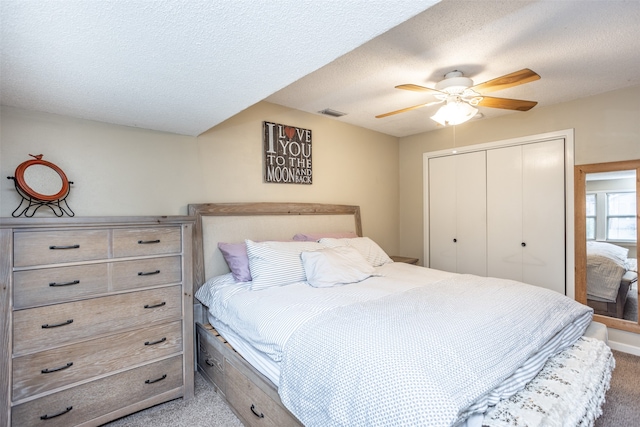 bedroom featuring a closet, ceiling fan, carpet floors, and a textured ceiling