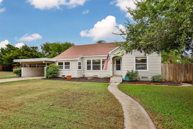 view of front of home with a carport and a front lawn