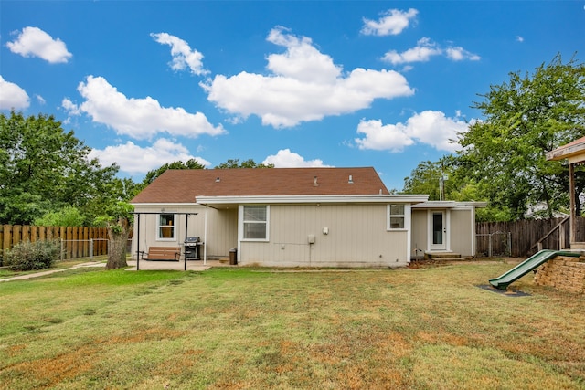 back of property with a yard and a patio area