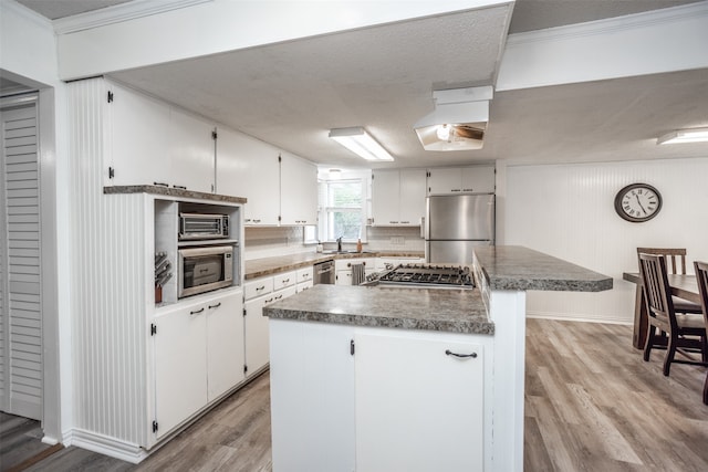 kitchen with a kitchen island, light hardwood / wood-style flooring, stainless steel appliances, and white cabinetry