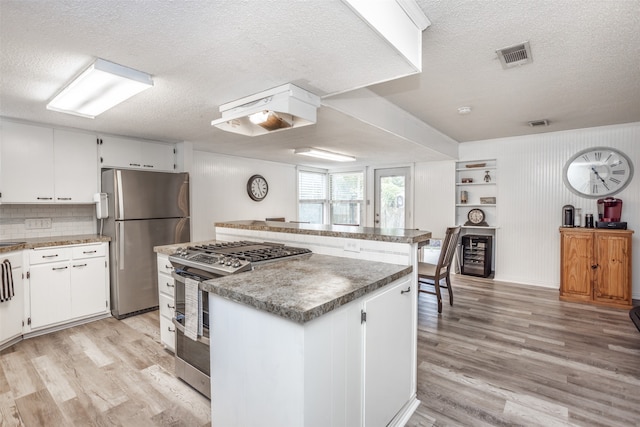 kitchen featuring stainless steel appliances, white cabinetry, and a kitchen island