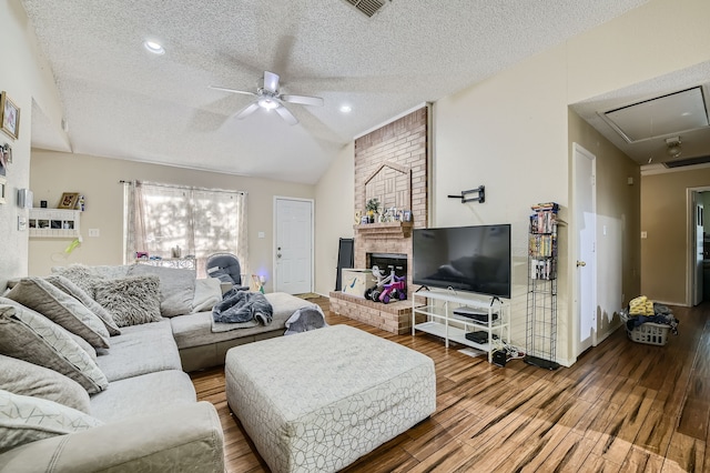 living room featuring a textured ceiling, vaulted ceiling, hardwood / wood-style floors, and ceiling fan