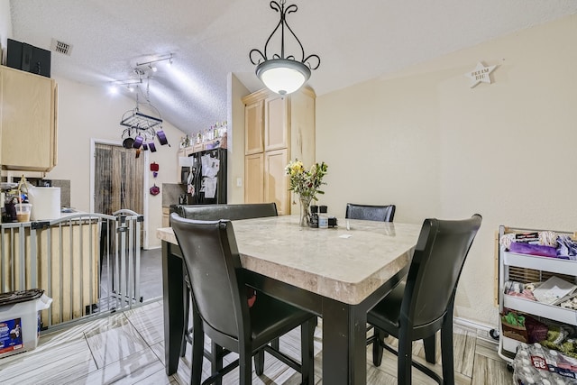 dining room with a textured ceiling and light wood-type flooring