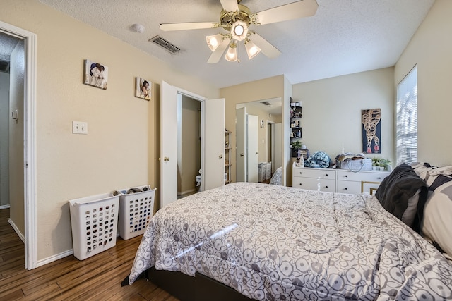 bedroom with a textured ceiling, wood-type flooring, and ceiling fan