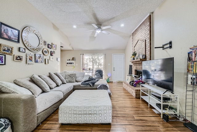 living room featuring vaulted ceiling, a textured ceiling, ceiling fan, and dark hardwood / wood-style flooring