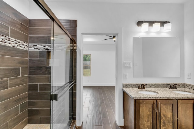 bathroom with vanity, hardwood / wood-style flooring, and a shower with door