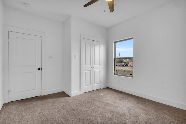 unfurnished bedroom with ceiling fan, carpet floors, and a closet