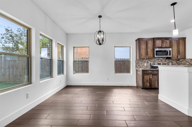 kitchen with dark hardwood / wood-style floors, decorative light fixtures, tasteful backsplash, dark brown cabinetry, and an inviting chandelier