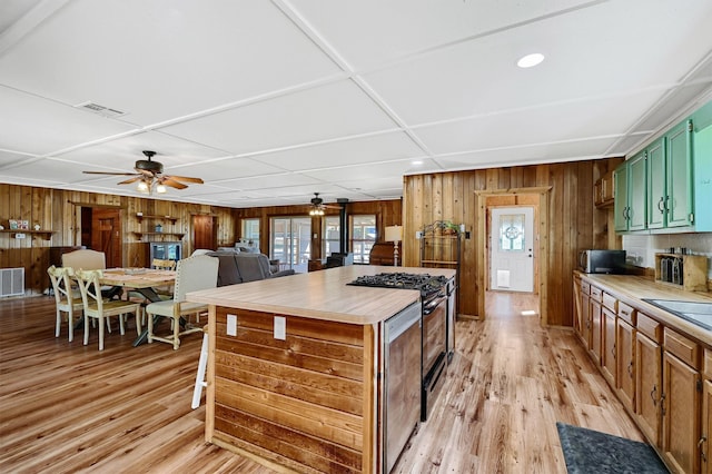 kitchen featuring ceiling fan, light hardwood / wood-style flooring, green cabinetry, and stainless steel range oven