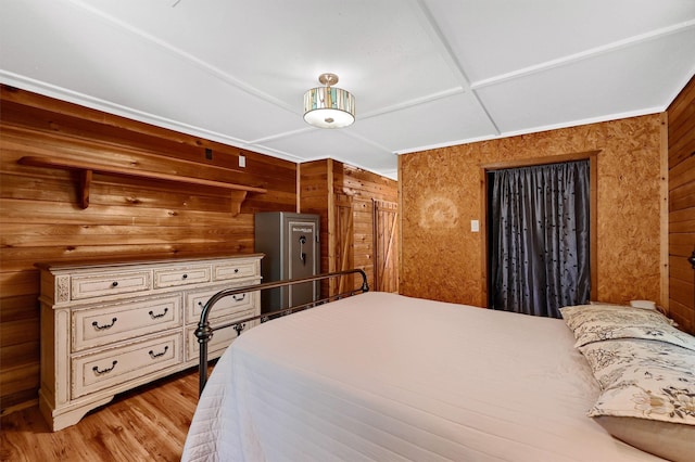 bedroom featuring wooden walls and light hardwood / wood-style flooring