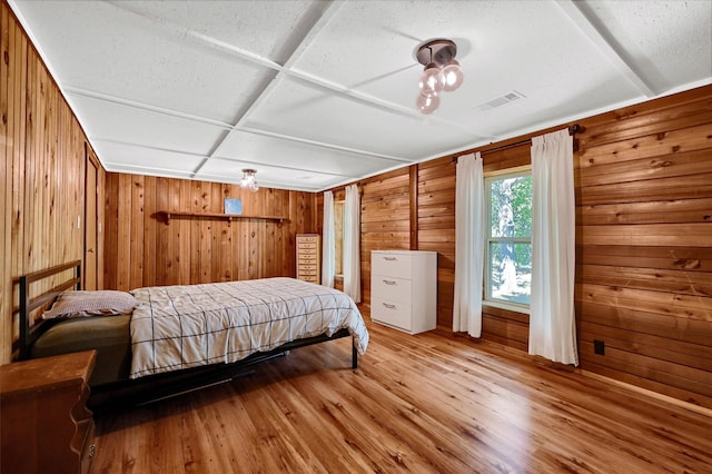 bedroom featuring hardwood / wood-style flooring and wooden walls