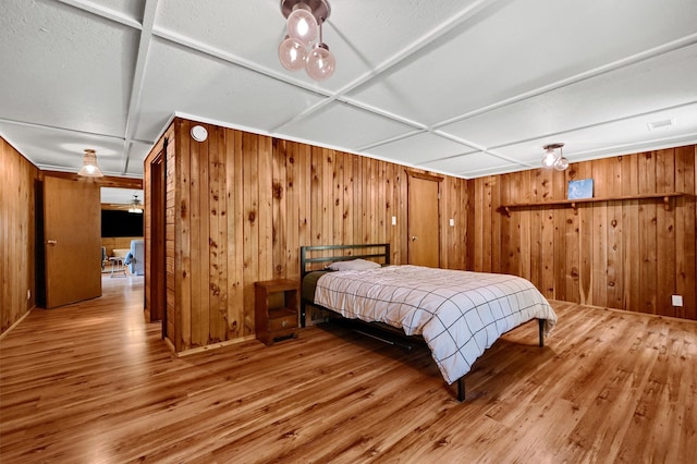 bedroom featuring wood-type flooring and wood walls