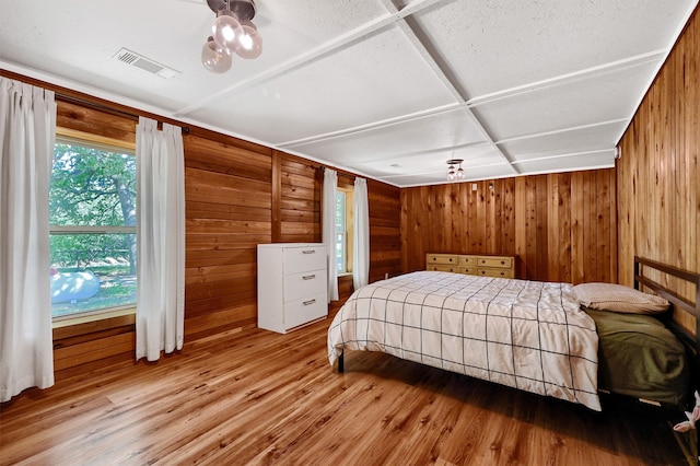 bedroom featuring wooden walls and light hardwood / wood-style flooring