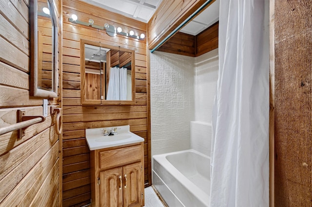 bathroom featuring vanity, shower / bath combo with shower curtain, and wooden walls