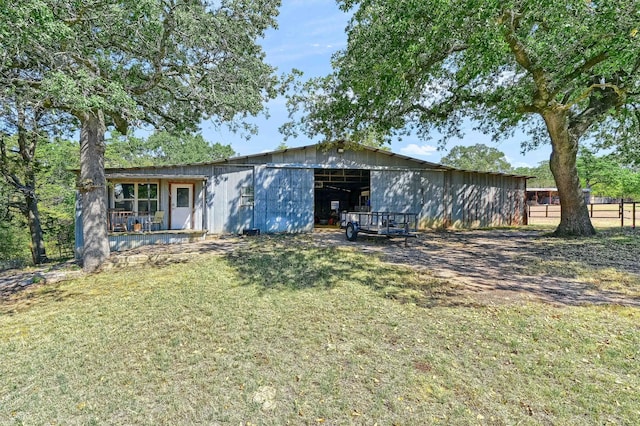 back of house featuring a lawn and an outdoor structure