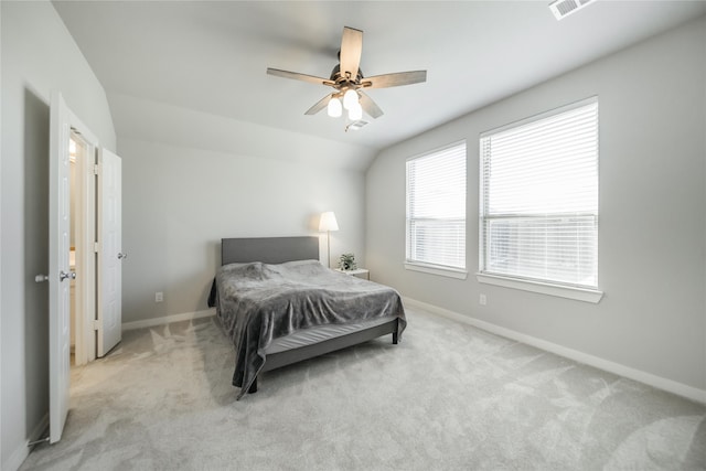 bedroom with ceiling fan, light colored carpet, and vaulted ceiling