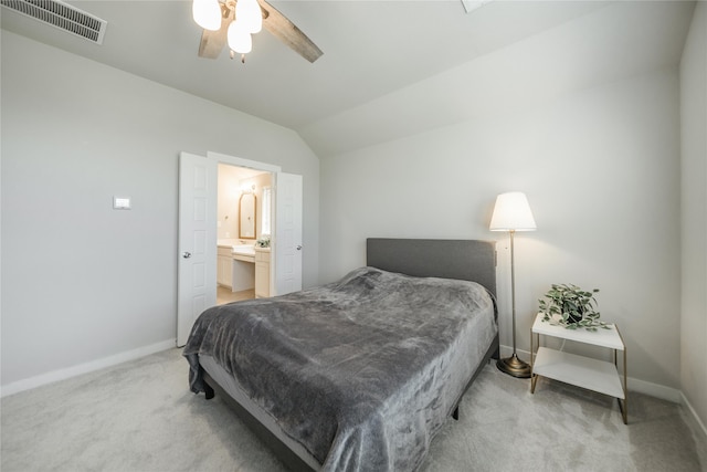 bedroom featuring ceiling fan, connected bathroom, vaulted ceiling, and light carpet