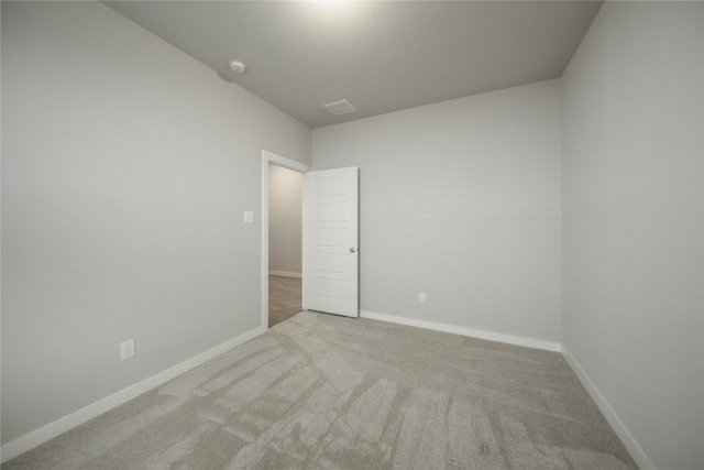 spare room featuring light colored carpet