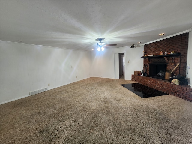 unfurnished living room featuring carpet floors, ornamental molding, ceiling fan, and a brick fireplace