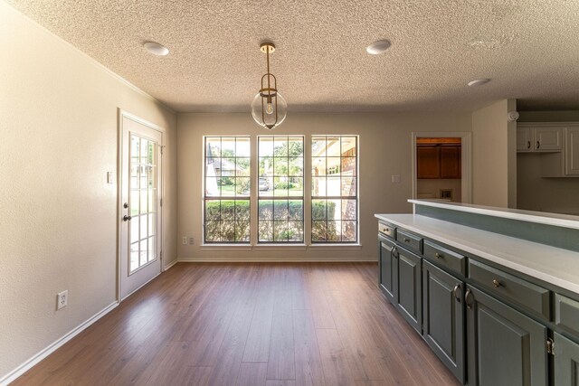 unfurnished living room with a textured ceiling, crown molding, hardwood / wood-style floors, and a notable chandelier