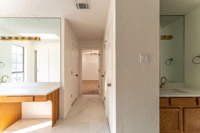 bathroom with a tub to relax in, a textured ceiling, and a skylight