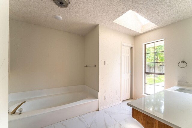 unfurnished bedroom featuring light wood-type flooring, ceiling fan, ensuite bathroom, and a textured ceiling