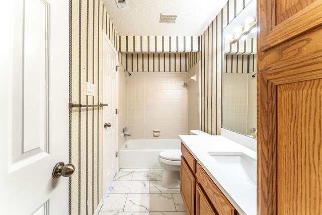 full bathroom with a textured ceiling, tiled shower / bath combo, vanity, and toilet