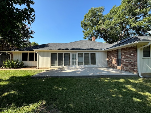 rear view of property featuring a lawn and a patio area