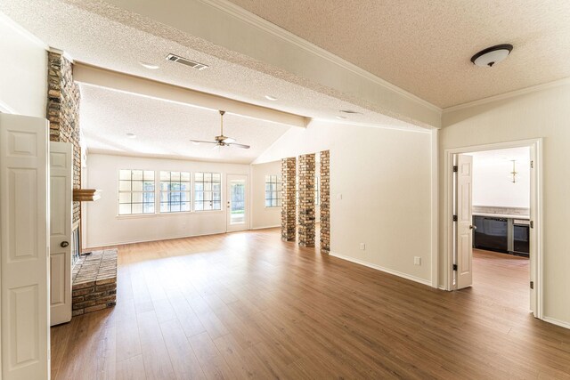 unfurnished living room with lofted ceiling with beams, a textured ceiling, hardwood / wood-style flooring, a fireplace, and ceiling fan