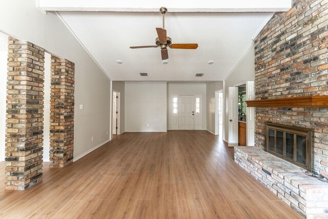 unfurnished living room with a textured ceiling, vaulted ceiling with beams, ceiling fan, and hardwood / wood-style flooring